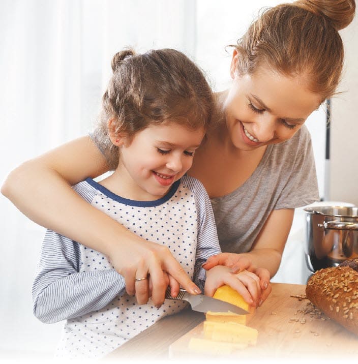 Woman and child slicing cheese