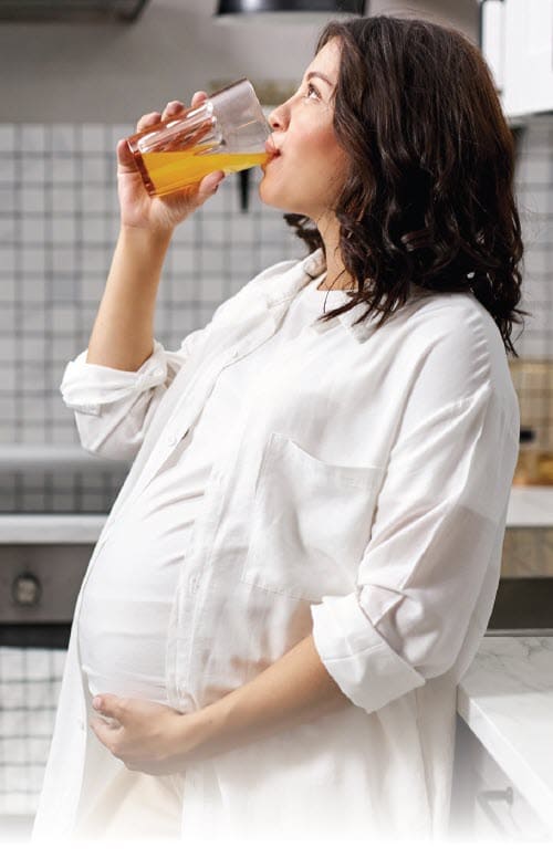 A pregnant woman drinking juice