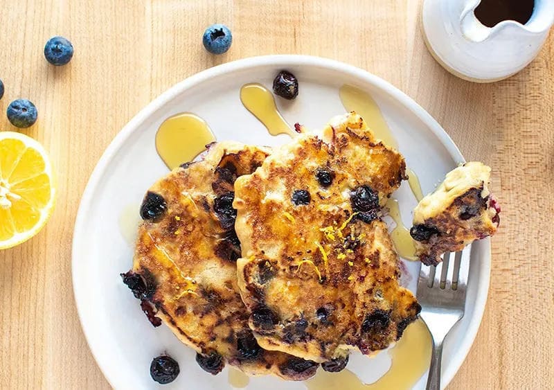 Lemon Blueberry Pancakes with syrup on a plate
