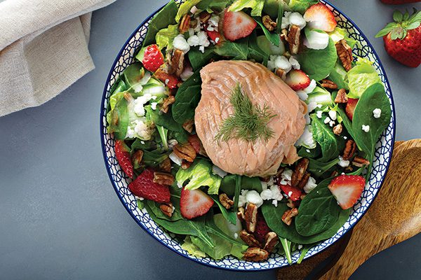 Salmon with veggies and yogurt dressing in a bowl